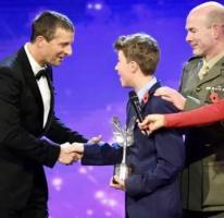 Max receives his award from Bear Grylls